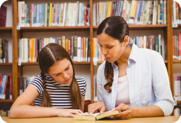 Teacher teaching student from a book